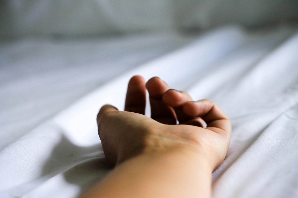 Mano descansando sobre sábanas blancas tras un masaje erótico terapéutico en Bliss Barcelona.