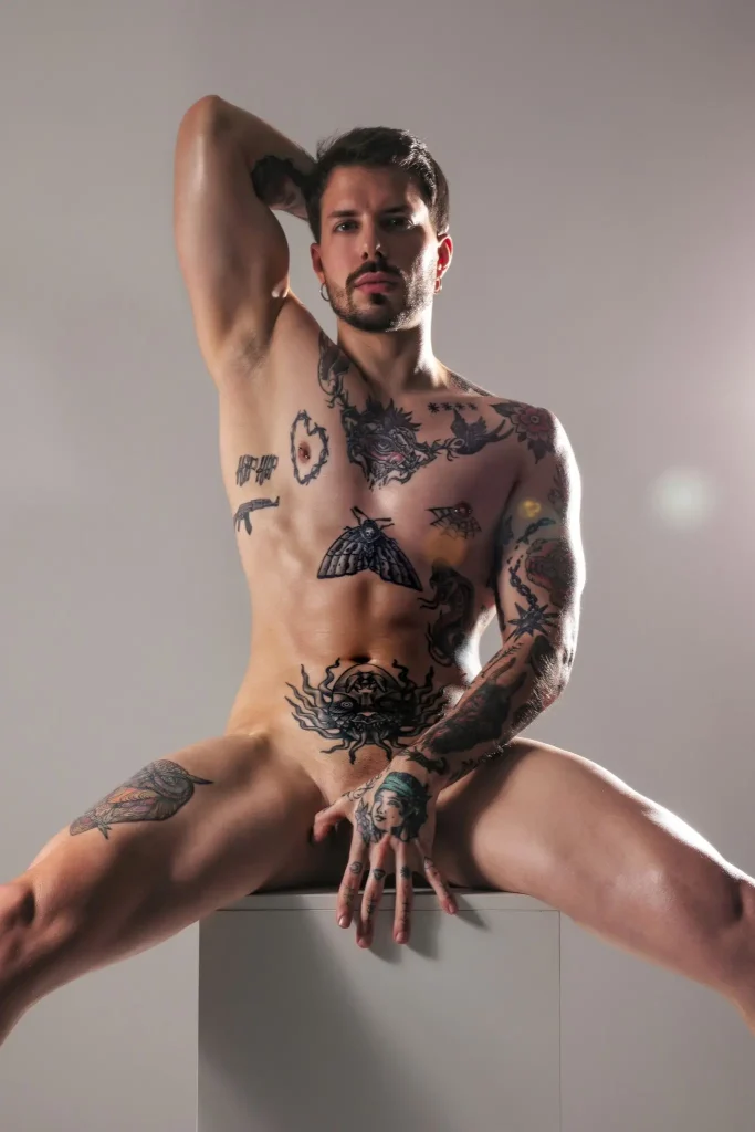 Enea, masajista de Bliss Barcelona, posando desnudo en estudio con cuerpo tatuado y expresión intensa