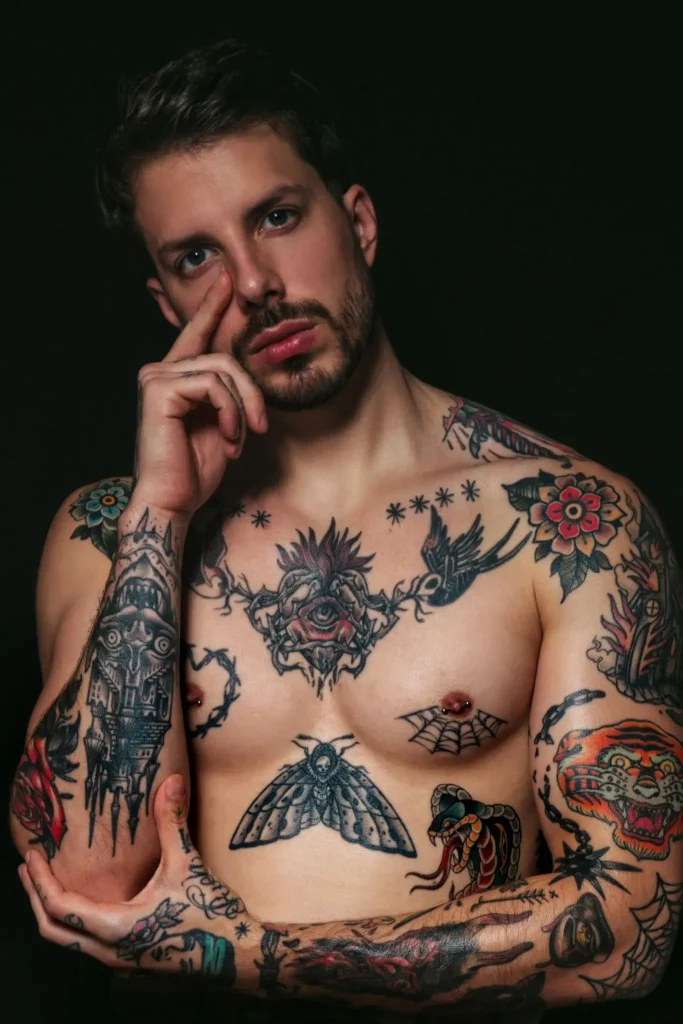 Enea, masajista de Bliss Barcelona, en retrato expresivo con gesto seductor y brazos tatuados