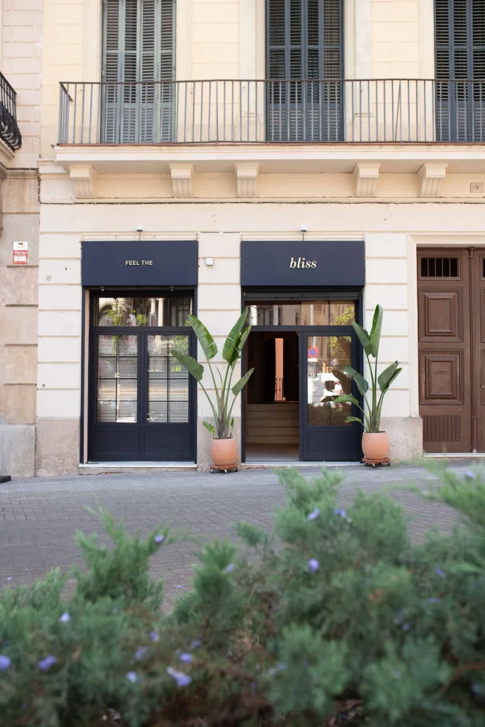 Fachada principal del centro Bliss en Barcelona con dos accesos, plantas tropicales y rótulos elegantes