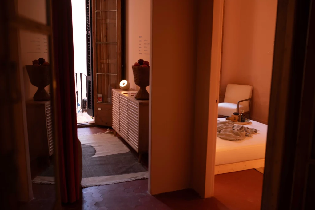 Habitación para masajes eróticos en Bliss con cama baja, luz cálida y decoración íntima en Barcelona