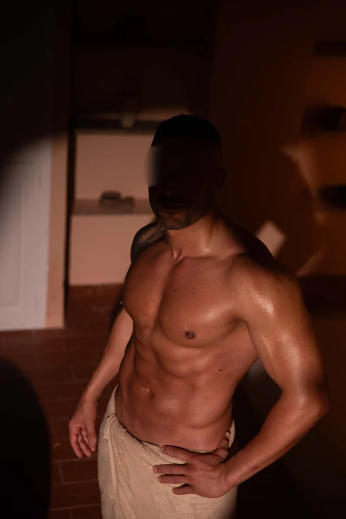 Masajista erótico masculino Aleix en toalla mostrando torso trabajado, Bliss Barcelona