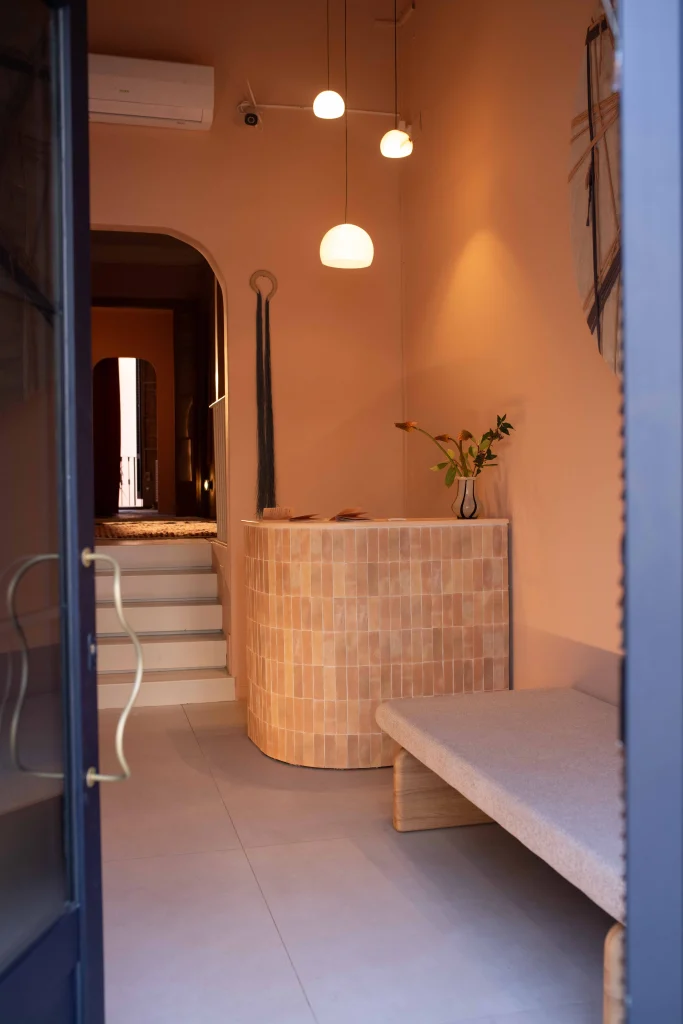 Entrada y recepción de Bliss Barcelona con mostrador curvo, iluminación suave y decoración natural